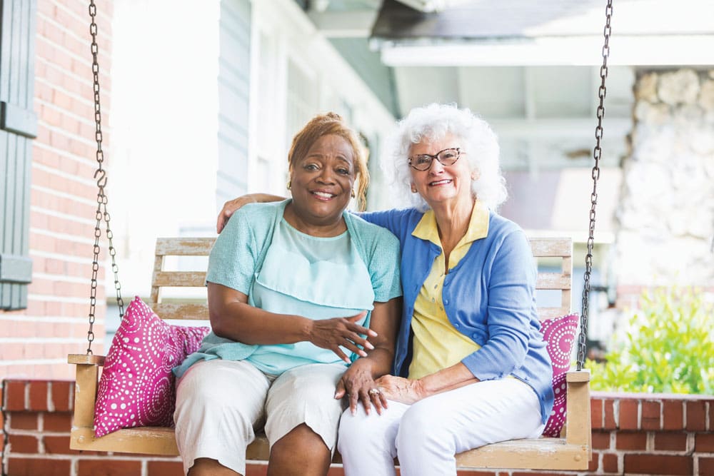 Two Independent Living Residents Rocking on a Porch Swing